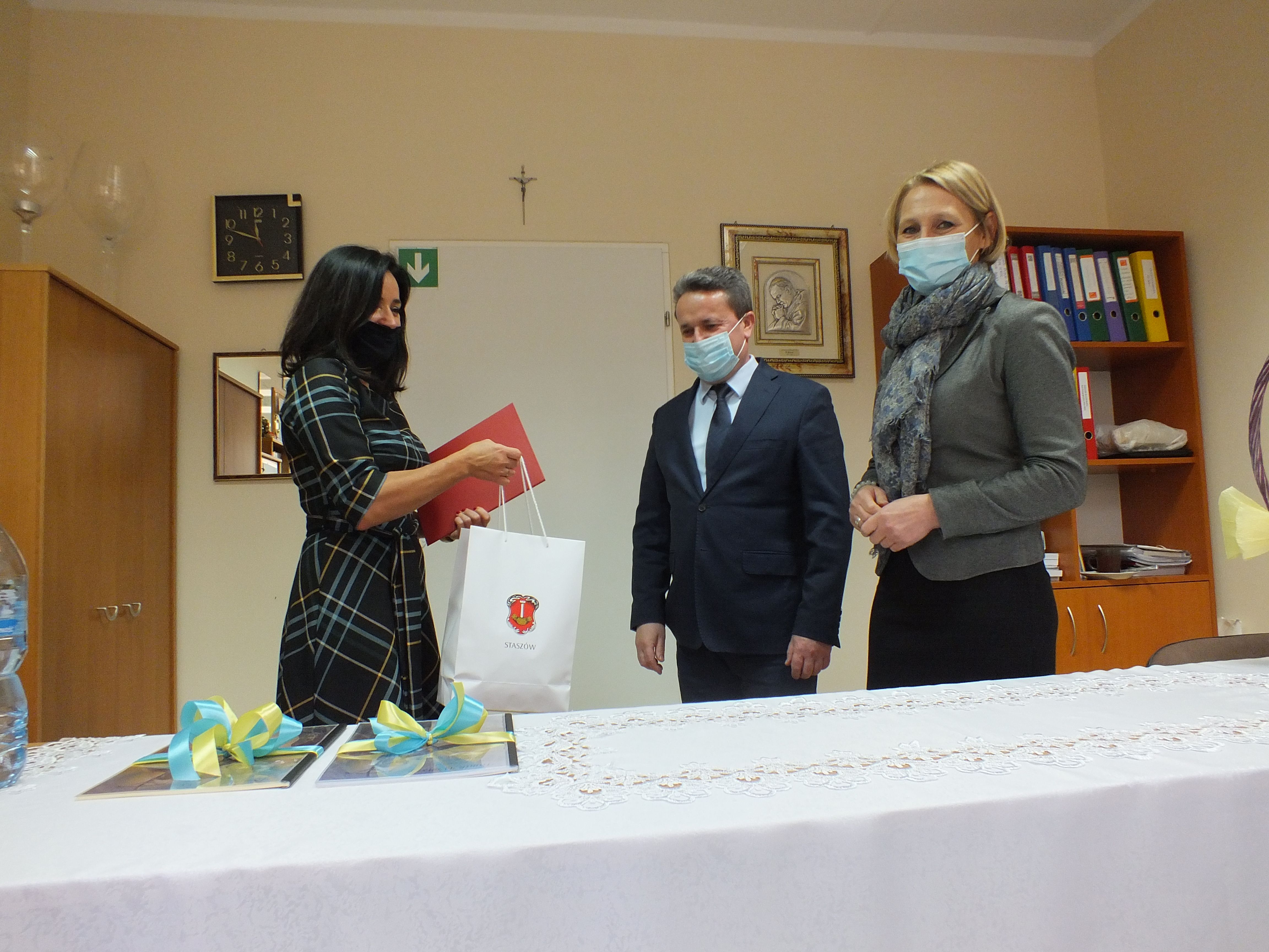 Na zdjęciu burmistrz Leszek Kopeć i zastępca burmistrza Ewa Kondek wręczają list gratulacyjny oraz podarki dla dzieci na ręce dyrektor Doroty Dalach