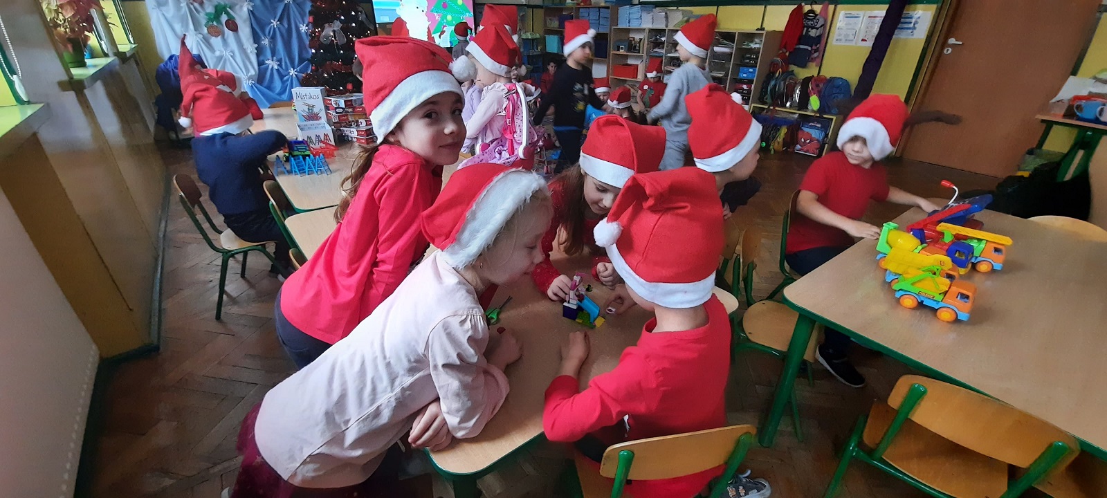 Na zdjęciu dzieci bawiące się zabawkami od świętego Mikołaja