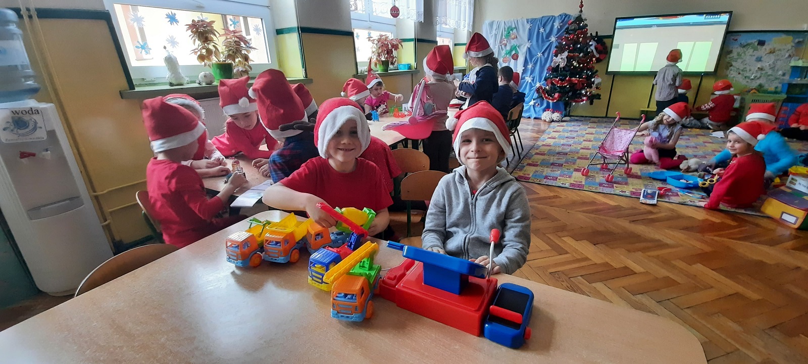 Na zdjęciu dzieci bawiące się zabawkami od świętego Mikołaja